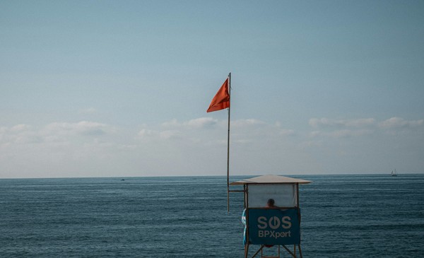 Drapeau rouge sur une plage française indiquant une baignade interdite