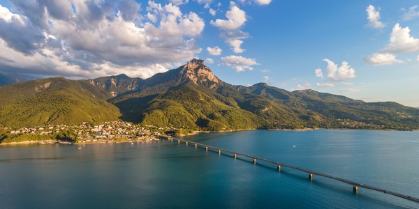 Village de Savines-le-Lac et pont sur le lac de Serre-Ponçon avec le pic du Grand Morgon (vue aérienne). Vallée de la Durance dans les Hautes-Alpes, Alpes, France