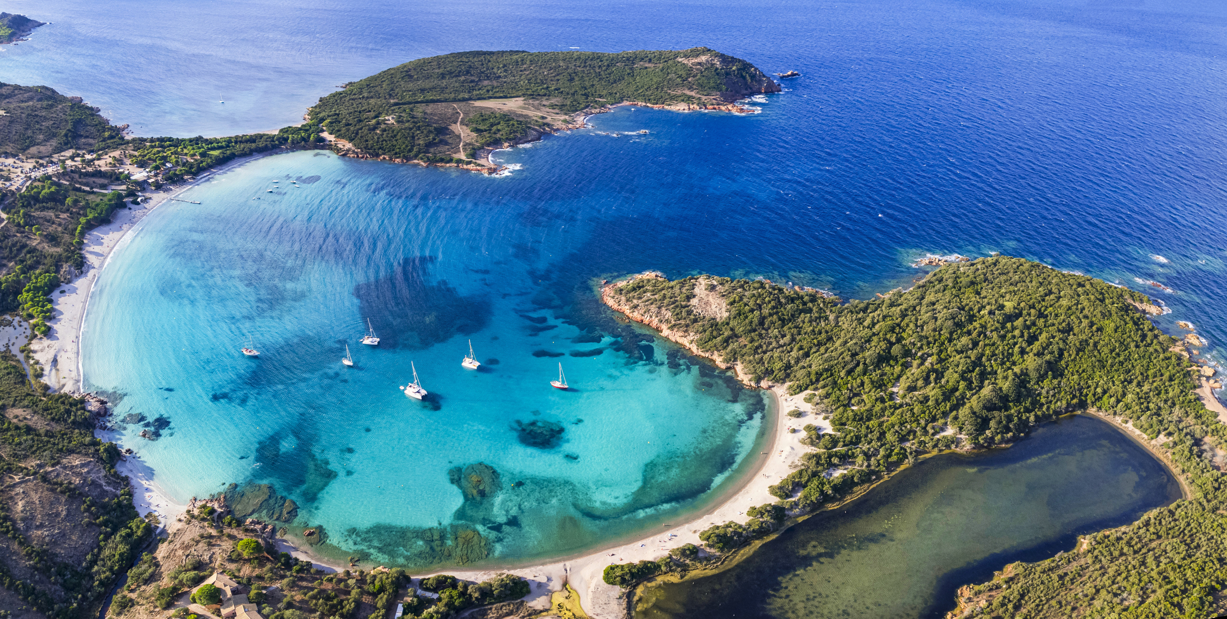 Les meilleures plages de l’île de Corse - vue panoramique aérienne de la belle plage de Rondinara avec une forme ronde parfaite et une mer turquoise cristalline